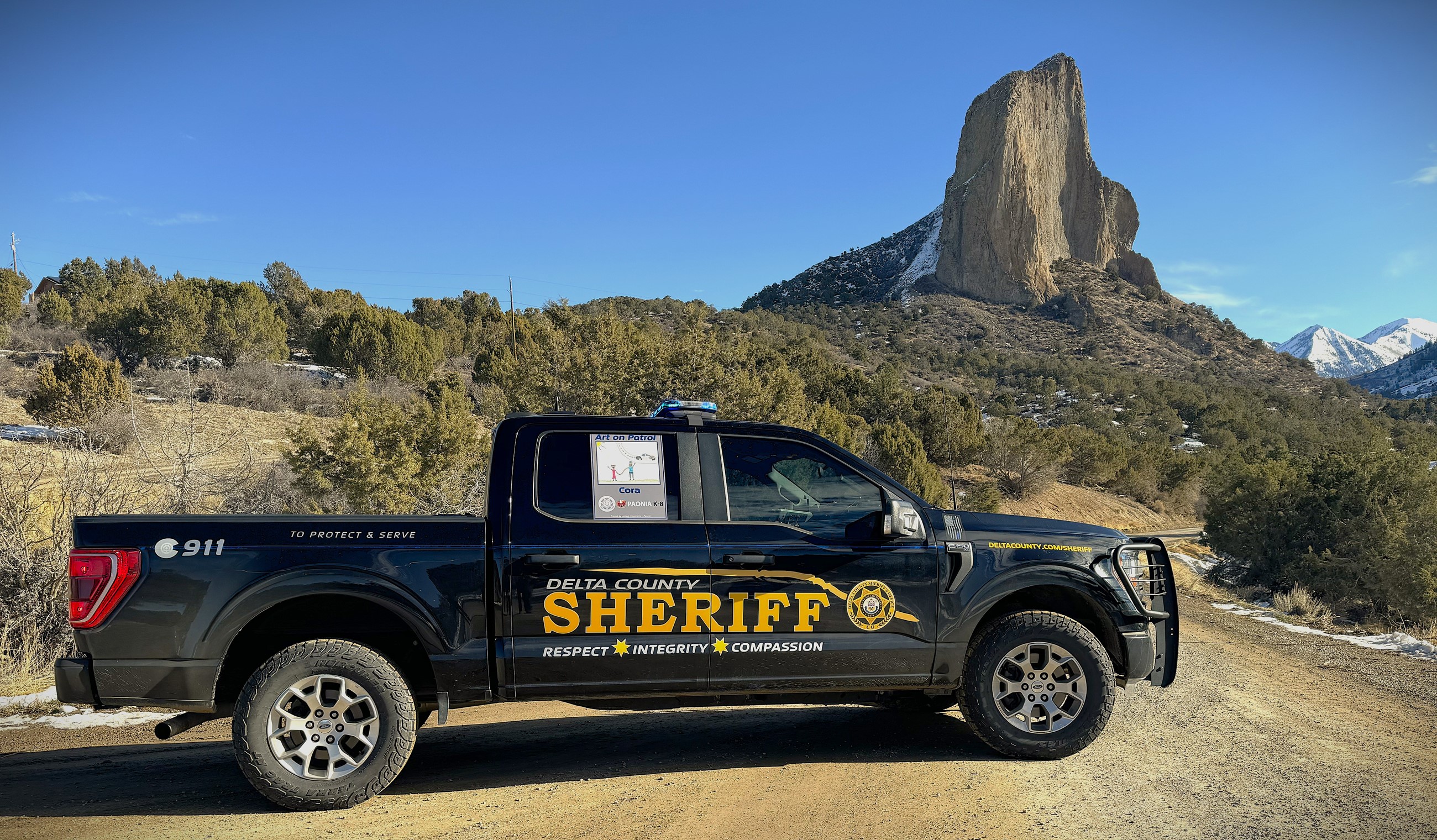 Sheriff's Office Patrol truck on dirt road in front of Needle Rock in Crawford 